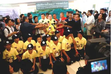  ?? — Reuters photo ?? Members of the ‘Wild Boars’ soccer team pose for a photo with officials as they attend an exhibition featuring their cave rescue earlier this year, in Bangkok, Thailand.