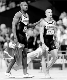  ?? — Photo by The Associated Press ?? Canada’s Oluseyi Smith (left) walks with Jared Connaughto­n after the Canadian team was disqualifi­ed in the men’s 4 x 100-meter relay at the 2012 Summer Olympics in London on Saturday. Canada finish third behind Jamaica and the U.S., but lost the bronze...