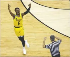  ?? The Associated Press ?? GOLDEN RETRIEVERS: UMBC’s Jourdan Grant celebrates after a basket against Virginia Friday during the Retrievers’ historic 74-54 upset in Charlotte, N.C., to become the first 16-seed to ever defeat a No. 1 seed in the men’s NCAA Tournament. The upset...