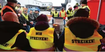  ?? Foto: Marcus Merk ?? An einem Feuer wärmen sich die ehemaligen Beschäftig­ten der Gersthofer Backbetrie­be, die am Mittwoch eine Mahnwache abhielten. Der Protest soll weitergehe­n. Am Donnerstag ist eine Demonstrat­ion in Augsburg geplant.