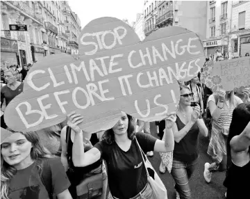  ??  ?? Protesters in Paris march to urge politician­s to act against climate change on Oct 13. — Reuters photo