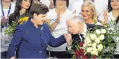 ?? Foto: dpa ?? Blumen für die neue polnische Regierungs­chefin: PiS-Parteichef Jaroslaw Kaczynski gratuliert Beata Szydlo.
