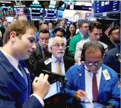  ??  ?? Traders work on the floor of the New York Stock Exchange (NYSE) in New York, US. Investors are banking on tame inflation and interest rates to support US stock prices and help counter any concerns over an anticipate­d slowdown in corporate earnings growth next year. — Reuters photo