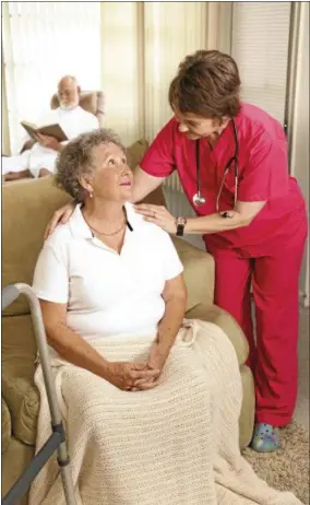  ??  ?? Nurse cares for an elderly woman in a nursing home.