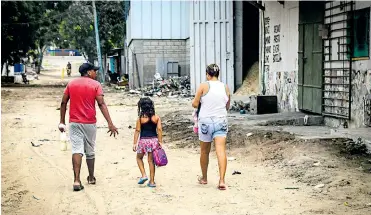  ?? ORLANDO AMADOR ?? Una familia camina por una de las calles de un barrio del municipio de Malambo.