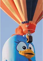  ?? JIM THOMPSON/JOURNAL ?? Balloonist­s get a bird’s-eye view of the Lottie Dottie Chicken balloon Tuesday morning.