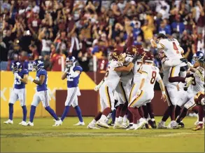  ?? Al Drago / Associated Press ?? Members of the Washington Football Team celebrate after kicker Dustin Hopkins hit the winning field goal against the New York Giants at the end of an NFL game on Thursday in Landover, Md. Washington won 30-29.