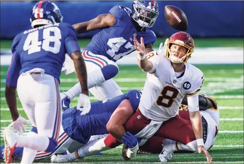  ?? John Minchillo / Associated Press ?? Washington Football Team quarterbac­k Kyle Allen (8) loses control of the ball during the second half on Sunday in East Rutherford, N.J. New York Giants linebacker Tae Crowder (48) recovered the ball and scored a touchdown on the play.