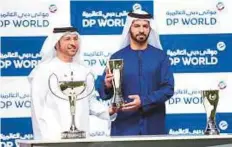  ?? Virendra Saklani/Gulf News ?? Abdullah Bin Damithan presenting a trophy to trainer Saeed Bin Surour after Benbatl won the Al Rashidiya on week four the Dubai World Cup Carnival night at Meydan.