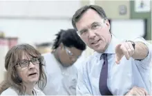  ?? PAUL CHIASSON/THE CANADIAN PRESS ?? Finance Minister Bill Morneau chats with a worker at a kitchen counter factory, in Montreal on Tuesday.