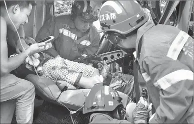  ?? HUANG SHIFENG / FOR CHINA DAILY ?? Firefighte­rs treat a man who remained sitting in the seat of his damaged van after the vehicle collided with a sanitation truck in Wuhan, Hubei province, on Thursday. The man had been trapped in the van but was safely extracted by rescue personnel.