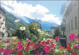  ??  ?? A mirror-like pool of lake in the Mont Blanc massif and, right, flowers bloom amid a backdrop of mountains in sun-kissed Chamonix