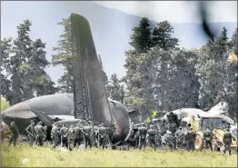  ?? RYAD KRAMDI/GETTY-AFP ?? A rescue team explores the wreckage of an Algerian military transport plane that crashed Wednesday near an air base in Boufarik, killing 247 passengers and 10 crew.