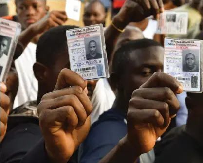  ?? FOTO: LEHTIKUVA/AFP PHOTO/ISSOUF SANOGO ?? VALDAG. Väljare håller upp röstkort i Liberias huvudstad Monrovia.