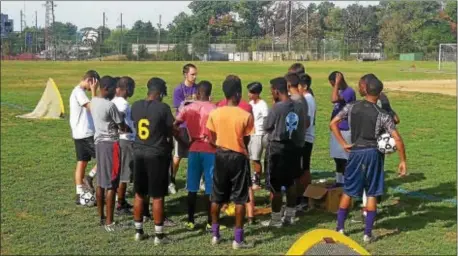  ??  ?? Upper Darby boys soccer coach Adam Edgar, week. center in purple shirt, convenes his team in a huddle after a practice last