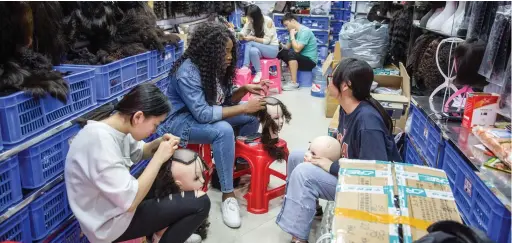  ??  ?? BOOM: African and Chinese women work at the Beauty Exchange Centre in Guangzhou, southern China. In the 2000s, during an economic boom in China, its African population rapidly started growing, building small businesses where people can buy almost...