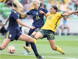  ?? AP ?? Australia’s Sam Kerr (right) scores against Sweden’s Nathalie Bjorn (centre) during their women’s friendly football match in Melbourne, Australia, in November. Australia’s opening Women’s World Cup match against Ireland has been moved to Stadium Australia in Sydney because of ticket demand, FIFA announced yesterday. The tournament, co-hosted by Australia and New Zealand, starts on July 20.