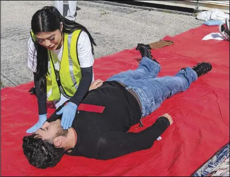  ?? JULIE DRAKE/VALLEY PRESS ?? Palmdale High School junior Ashley Martinez “assesses” senior Juan Del Rio during a make-believe disaster drill Tuesday
as part of training for CERT (Community Emergency Response Team) certificat­ion for Martinez and 93 other juniors.