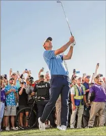  ?? Steph Chambers / Getty Images ?? Scottie Scheffler plays an approach on the 18th hole in the final round of the Phoenix Open in Scottsdale, Arizona. His 19-under 265 gave him a two-stroke win.