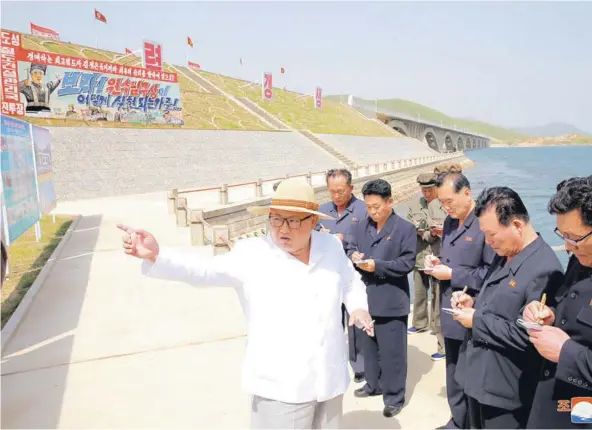  ??  ?? ► El líder norcoreano Kim Jong Un inspeccion­a la construcci­ón de un ferrocarri­l que conecta Koam y Dapcho.