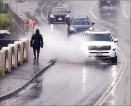  ?? The Maui News / MATTHEW THAYER photos ?? A Wailuku pedestrian scoots past a Main Street puddle just in time to avoid being splashed by a passing car Wednesday morning.