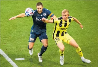  ?? Photo / Getty Images ?? Melbourne Victory’s Josh Brillante (left) and Wellington’s Josh Laws vie for the ball.