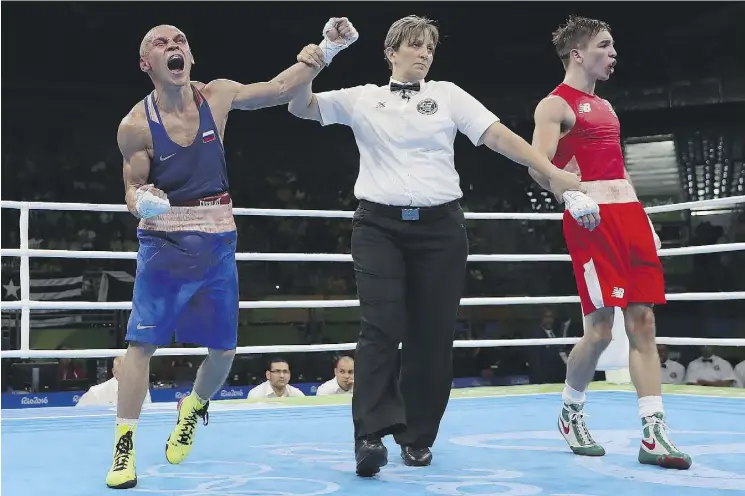  ?? CHRISTIAN PETERSEN/GETTY IMAGES ?? Russia’s Vladimir Nikitin, left, celebrates his victory over Michael John Conlan of Ireland in men’s bantam boxing at Riocentro on Tuesday.