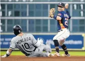  ?? ERIC CHRISTIAN SMITH/AP ?? The Astros’ Jose Altuve attempts to turn a double play over Yoán Moncada on June 19.