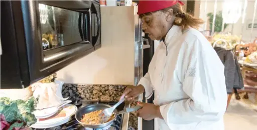  ?? TYLER LARIVIERE/SUN-TIMES ?? Josephine “Mother” Wade, owner of Josephine’s Southern Cooking in Chatham, prepares a dish Monday in her home kitchen.