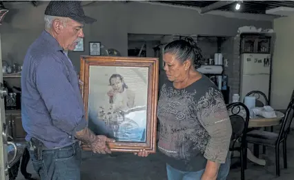  ?? Photos by Daniel Berehulak, © The New York Times Co. ?? José Luis Silva and Justina Zamarripa of Chihuahua, Mexico, show a photo of Jéssica, their daughter, who was killed during the takeover of the dam.