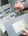  ?? FOTO: DPA ?? Kriminelle montieren Vorsatzger­äte an den Kartenschl­itz des Geldautoma­ten, um die Kartendate­n auszulesen. Mittels einer aufgesetzt­en Zusatztast­atur gelangen sie an die PIN-Nummer.