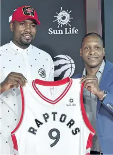  ?? FRANK GUNN/THE CANADIAN PRESS ?? Raptors forward Serge Ibaka and team president Masai Ujiri smile as they hold a jersey during a Friday news conference in Toronto. The team has signed both Ibaka and free agent point guard Kyle Lowry to three-year contracts.