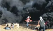  ?? AFP ?? A man uses a slingshot to throw a stone towards Israeli forces.