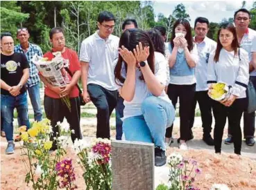  ?? PIC BY POLIANA RONNIE SIDOM ?? Vivian Wong Shir Yee crying at the grave of her father, Datuk Stephen Wong, at the Christian Cemetery in Sandakan yesterday.