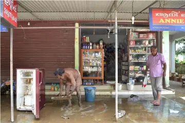  ?? — AFP photo ?? File photo shows an Indian shopkeeper cleaning out his shop after flood waters receded in Pandanad in Alappuzha District in the south Indian state of Kerala.