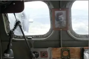  ?? The Sentinel-Record/Grace Brown ?? UNIQUE TOUCH: A photo of a World War II sweetheart sits at a desk inside the nose of the fully restored B-17 bomber Sentimenta­l Journey on Monday as it flies over the city.