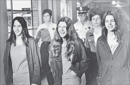  ?? Associated Press ?? MANSON “FAMILY” MEMBERS Susan Atkins, left, Patricia Krenwinkel and Leslie Van Houten laugh as they are escorted into court Aug. 11, 1970, in Los Angeles.