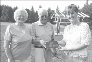  ??  ?? Bev and Milt Loomis being presented with a plaque that will be mounted next to the new interpreti­ve panel being built at the Milby School house.