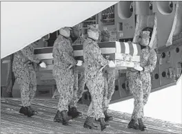  ?? PATRICK SEMANSKY/AP ?? A Navy team moves a transfer case containing the remains of civilian Scott Wirtz on Saturday at Dover Air Force Base, Del. He and three other Americans were killed in Syria.