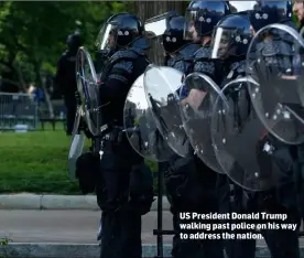  ??  ?? US President Donald Trump walking past police on his way to address the nation.