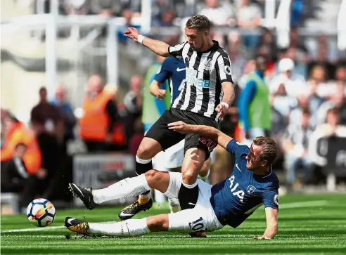 ?? — Reuters ?? Staying firm: Tottenham Hotspur’s Harry Kane tackling Newcastle’s Florian Lejeune in the English Premier League match at St James’ Park last Sunday. Tottenham won 2- 0.