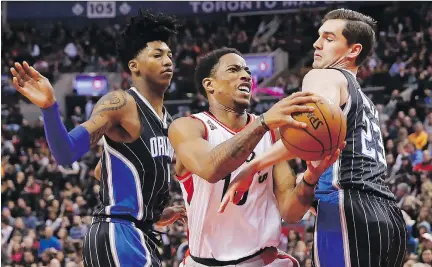  ?? MARK BLINCH/THE CANADIAN PRESS ?? The Raptors’ DeMar DeRozan goes to the basket against Orlando Magic’s Elfrid Payton, left, and Mario Hezonja in Toronto on Sunday. DeRozen had 25 points in Toronto’s 105-100 victory.