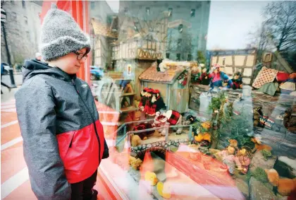  ?? JOHN MAHONEY ?? Lars Schougaard, 8, takes in The Mill In the Forest display outside the McCord Museum on Tuesday. The Enchanted Village display, which also originated as an annual display at the Ogilvy department store, is now located in a room on the second floor of the museum.