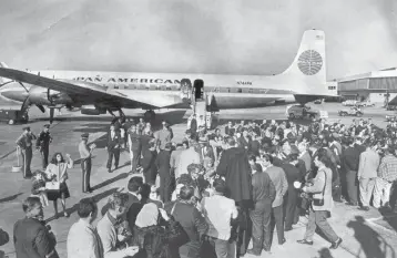  ?? Historical Museum of Southern Florida ?? Cuban refugees aboard the historic first Freedom Flight arrive at Miami Internatio­nal Airport on Dec. 1, 1965 to a sea of relatives and reporters.