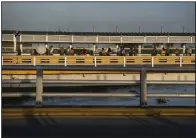  ?? (Bloomberg/Callaghan O’Hare) ?? People form a line and wait to enter the United States on the Gateway Internatio­nal Bridge at Brownsvill­e, Texas.