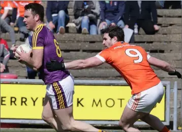  ??  ?? Wexford captain Daithí Waters shakes off the close attention of Armagh’s Aaron Findon.