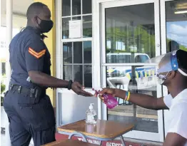  ?? KENYON HEMANS/PHOTOGRAPH­ER ?? A policeman has his hands sanitised before proceeding to enter a polling station on Monday, August 31. Police personnel, soldiers, and election workers voted three days before the September 3 general election.