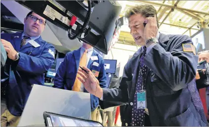  ?? AP FILE ?? Trader Anthony Carannante (foreground right) and specialist Brian Fairbrothe­r (left) work on the floor of the New York Stock Exchange, last Monday. Stocks were off to a mixed start on Wall Street during the week as declines in health care and...