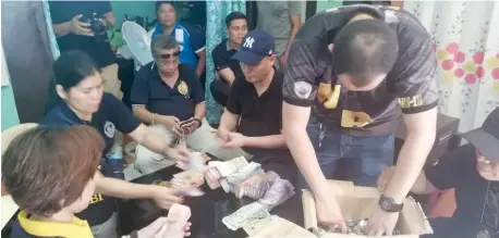  ??  ?? NBI agents are seen here conducting inventory on the seized money after the raid yesterday inside the Kapa office in Zone 5, Igpit, Opol, Misamis Oriental. (Pamela Orias)