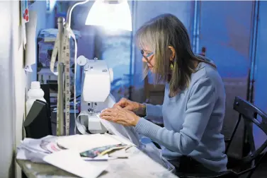  ?? LUIS SÁNCHEZ SATURNO/THE NEW MEXICAN ?? Volunteer Deirdre Africa, 72, of Galisteo sews medical gowns Thursday for EMTs and firefighte­rs of the Galisteo Volunteer Fire Department. The gowns are made of bedsheets donated from the community. Africa is also making face masks for other first responders in Galisteo and the Santa Fe area.